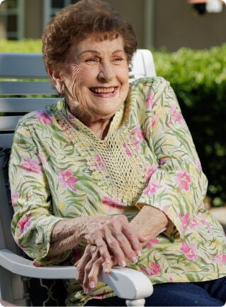 woman with a floral blouse sitting outside