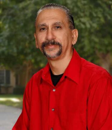 man with a beard and grayish hair in a red shirt