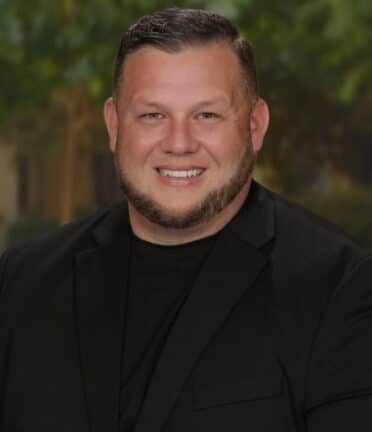 smiling man with a black shirt and a beard